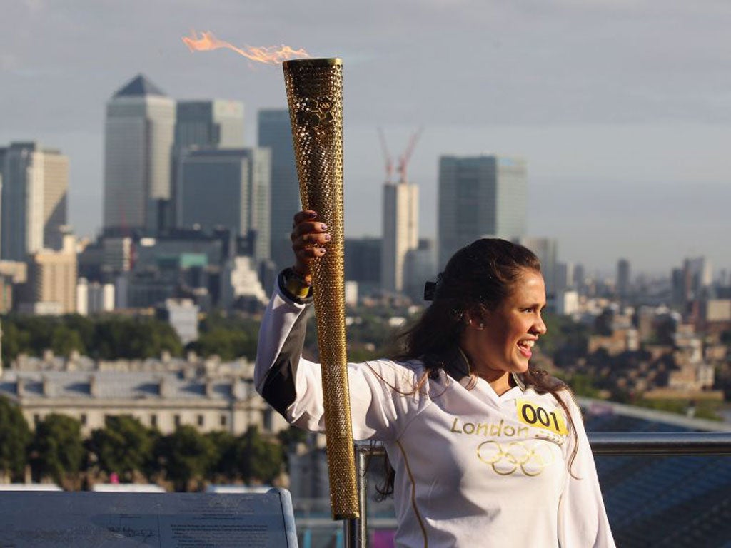 Natasha Sinha, 15, holds the Olympic torch aloft at the Observatory in Greenwich Park