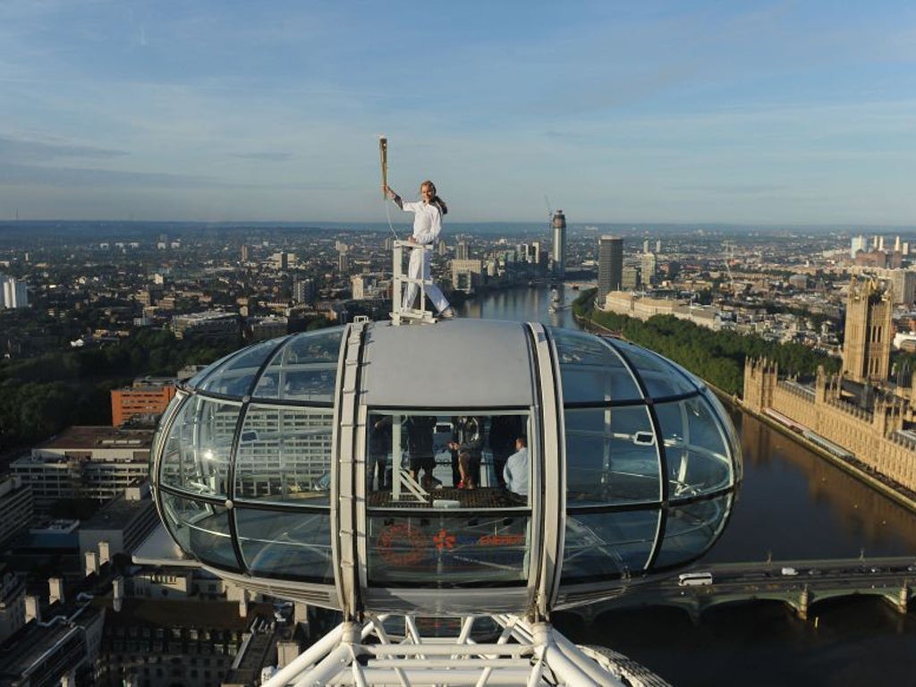 Amelia Hempleman-Adams poses with the Olympic Flame on top of a London Eye pod