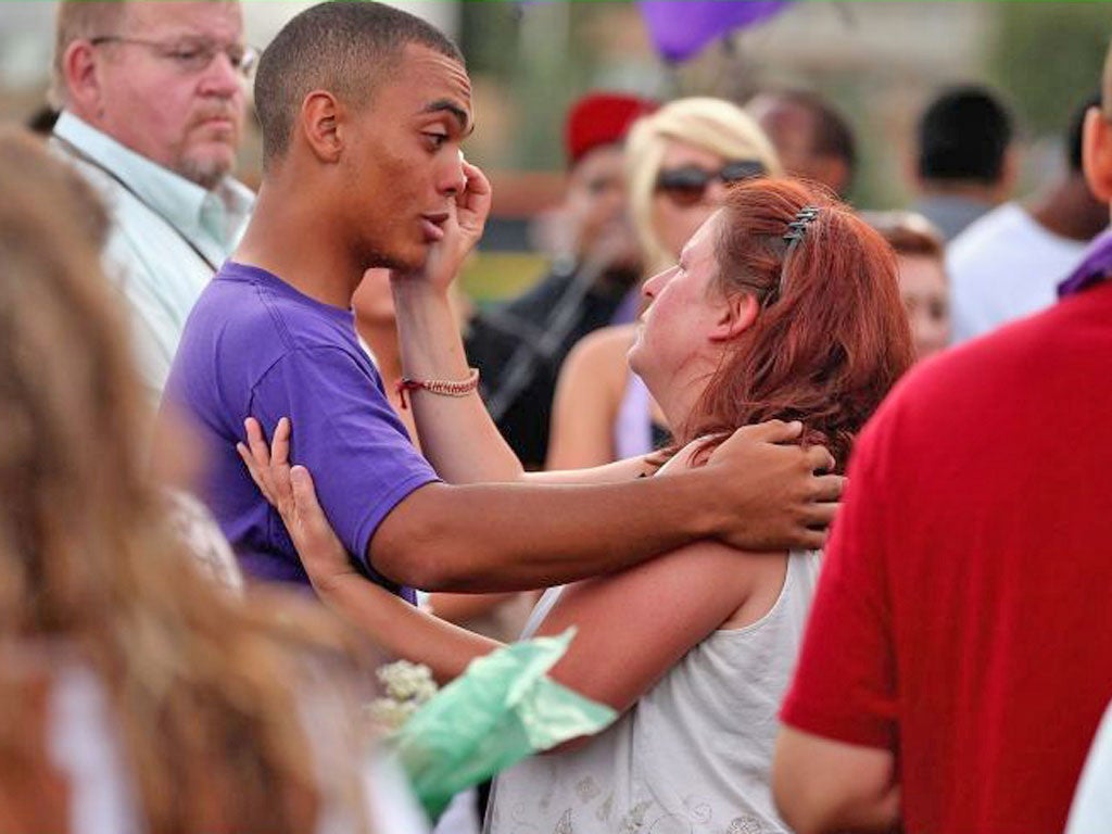 Shooting victim Alexander Boik’s mother comforts one of her son’s friends at a memorial service in Aurora, Colorado, on Saturday