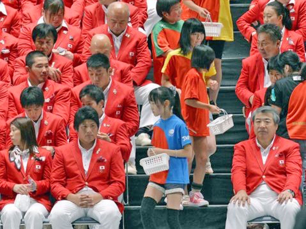 Children from the tsunami-hit regions hand out good-luck charms to Japan’s Olympians at a ceremony in Tokyo