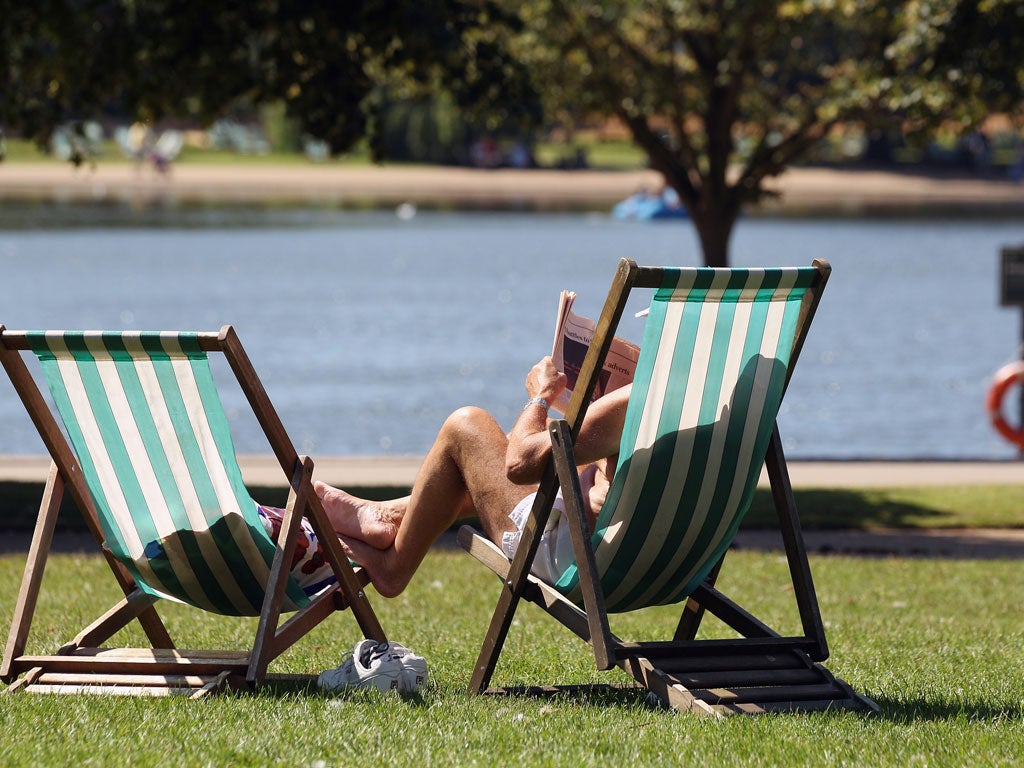 A man soaks up the sun in Hyde Park, London