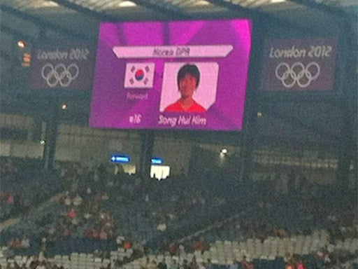 The South Korean flag is displayed alongside one of North Korea's players on the big screen