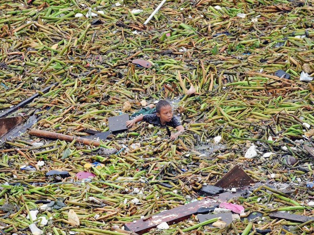 A young boy tries to looks for his belongings after a storm hit the
Philippines capital Manila yesterday