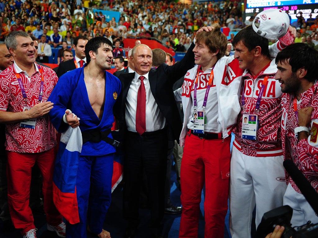 President Vladimir Putin celebrates Tagir Khaibulaev's gold medal in the Men’s under-100kg judo competition