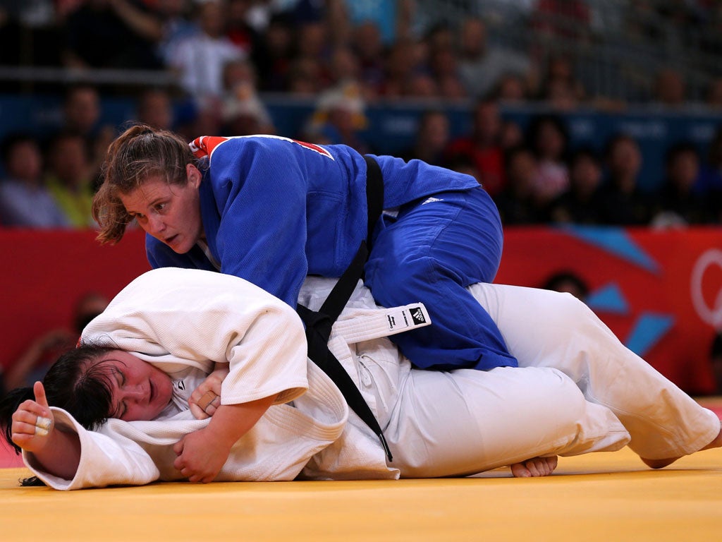 Karina Bryant (top) tussles with Iryna Kindzerska in their bronze medal match