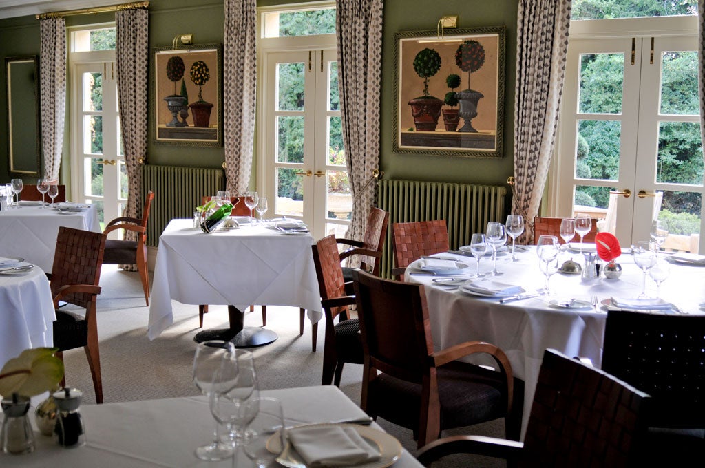 The dining-room is formal, with large, well-spaced tables and taupe-teal walls