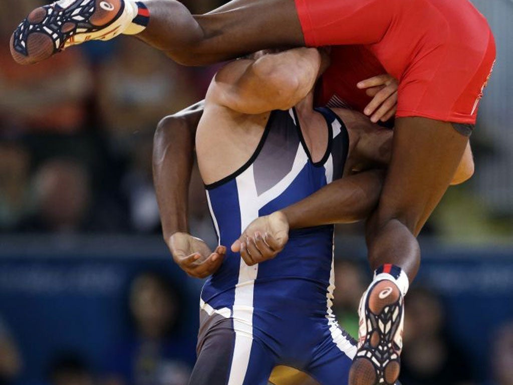 Ellis E Coleman of the United States (in red) competes against Ivo Serafimov Angelov of Bulgaria during the 60-kg Greco-Roman wrestling