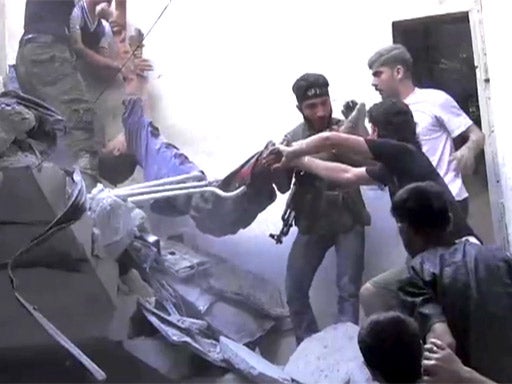 A boy is pulled from the rubble of his family house in the Bustan al-Qasr district of Aleppo