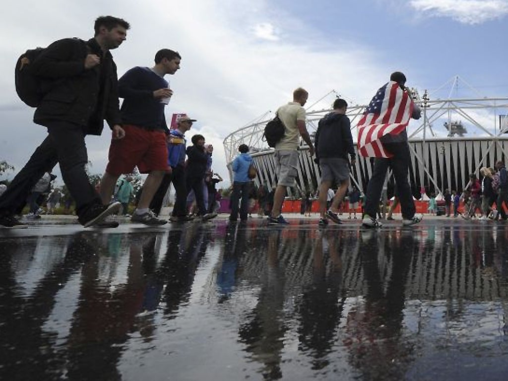 29 July: Fans suffer the weather outside the Olympic Stadium in Stratford