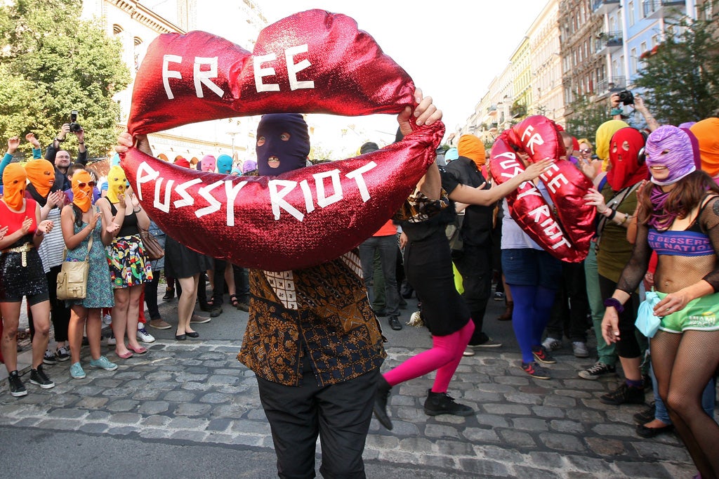 Background actors wearing masks perform during the recording of a music video of Canadian musician and performance artist Peaches in support of members of the feminist punk group Pussy Riot in Berlin, Germany
