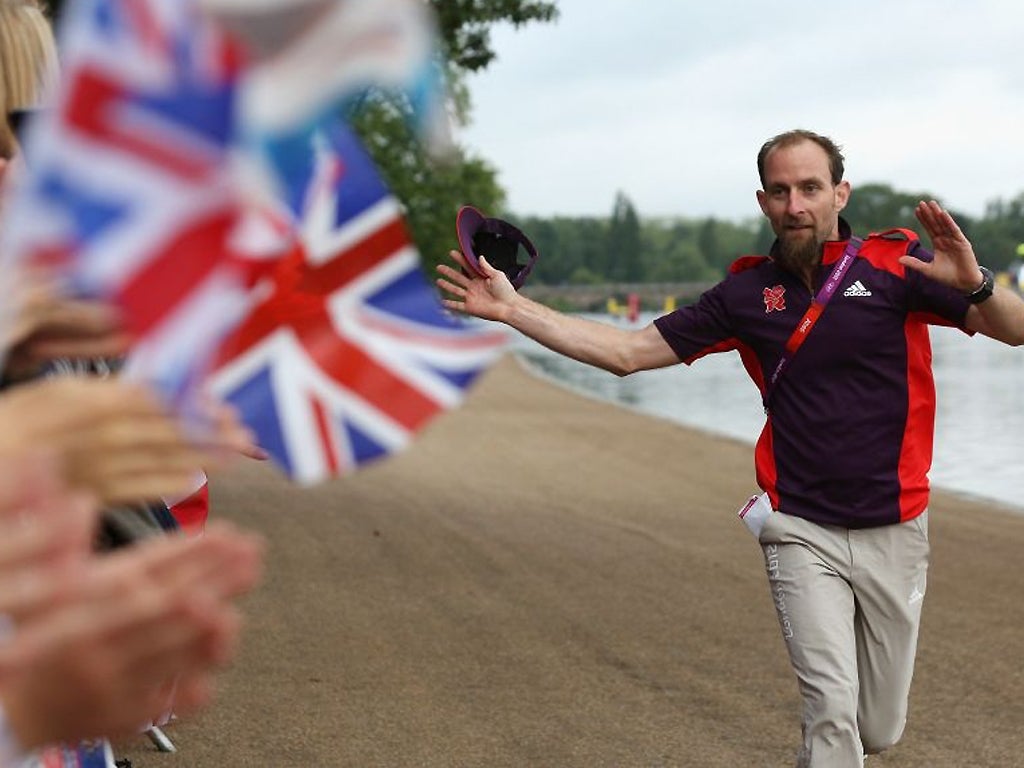 Welcome! A volunteer entertains fans waiting to watch athletes compete in the swimming stage of the Women's Triathlon in Hyde Park