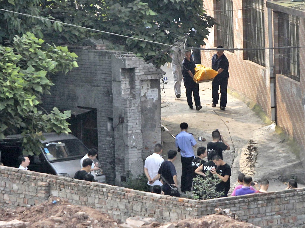 Police carry away the body of Zhou Kehua from the spot he was shot dead