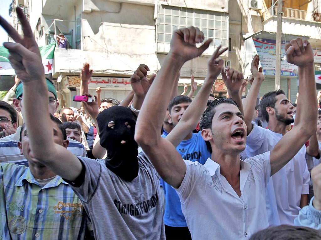 Anti-regime protesters shout slogans during a demonstration in Aleppo