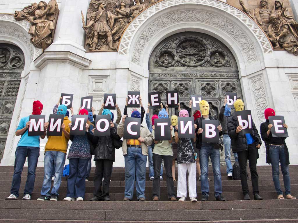 Supporters of punk group Pussy Riot, wearing the group's trademark coloured balaclavas, hold individual letters that spell the phrase 'Blessed are the merciful' outside the Church of Christ the Saviour in Moscow