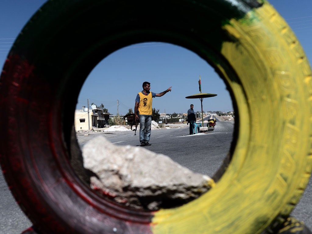 Spotlight: A Kurd guards a checkpoint on the Syrian-Turkish border