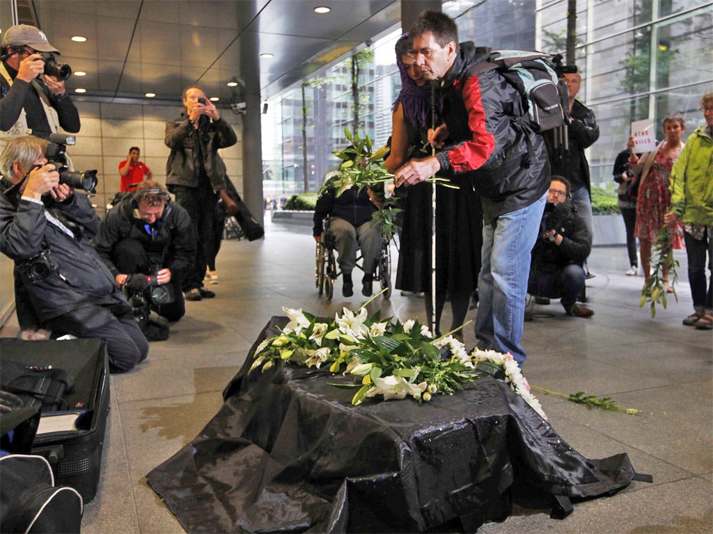 Disability protesters leave a coffin of messages outside the Atos headquarters during a protest in 2012