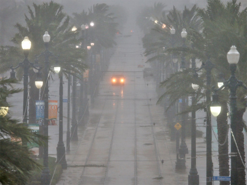 A driver braves a sodden Canal Street in New Orleans yesterday