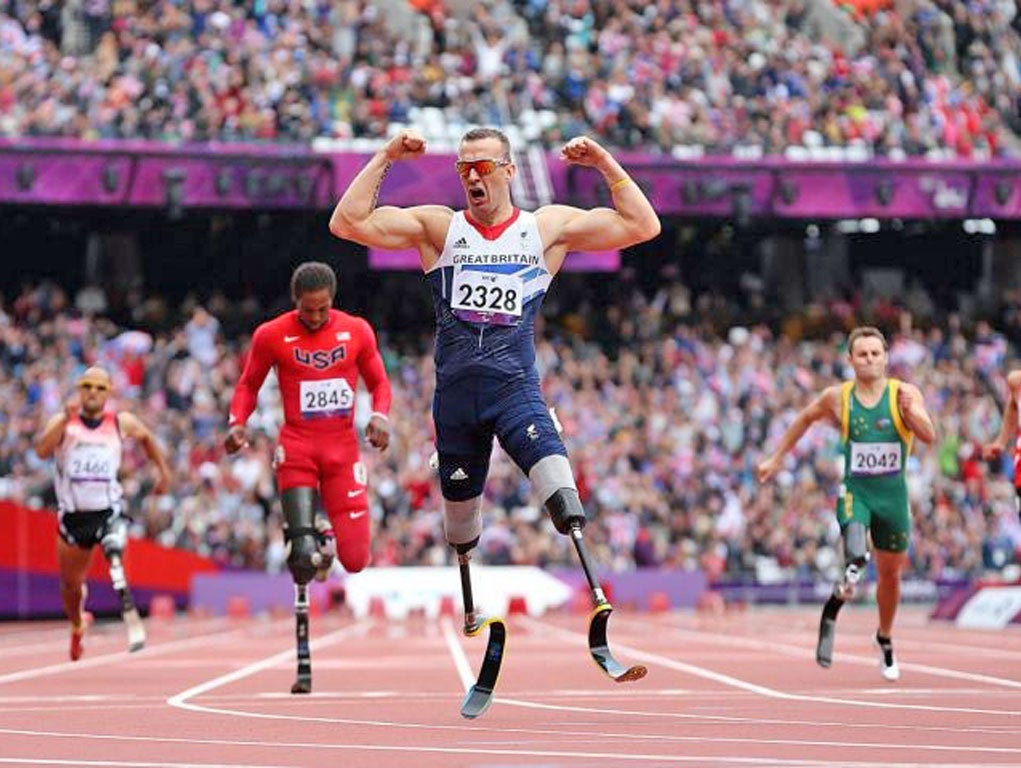 Strong man: Richard Whitehead roars his delight and flexes his muscles as he crosses the line for victory in the 200m final