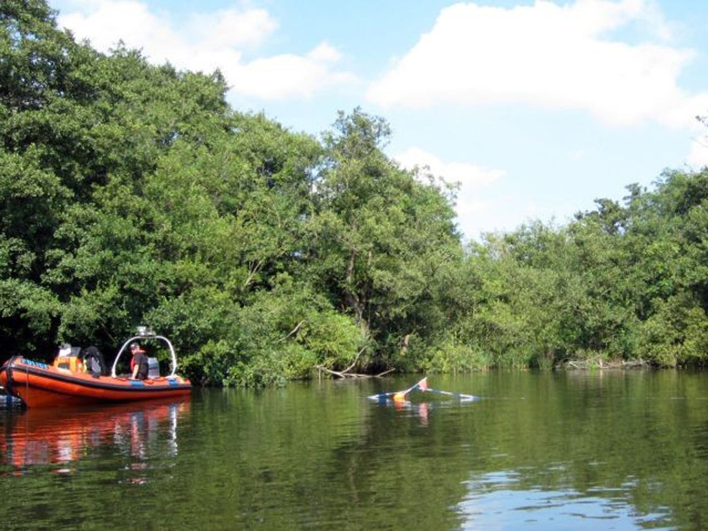 Police at the scene on a stretch of the River Bure between Wroxham Broad and Salhouse Broad, Norfolk, where a 13-year-old girl was found alone on a rented boat on Saturday