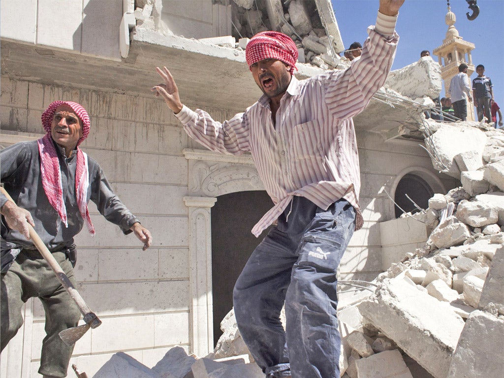 Civilians go through a destroyed building in al-Bab following an air strike this week