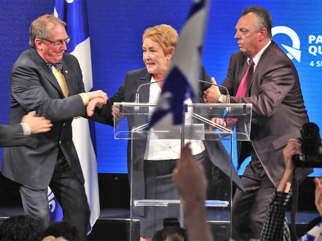 Quebec separatists’ leader Pauline Marois is whisked off stage as she delivers her victory speech