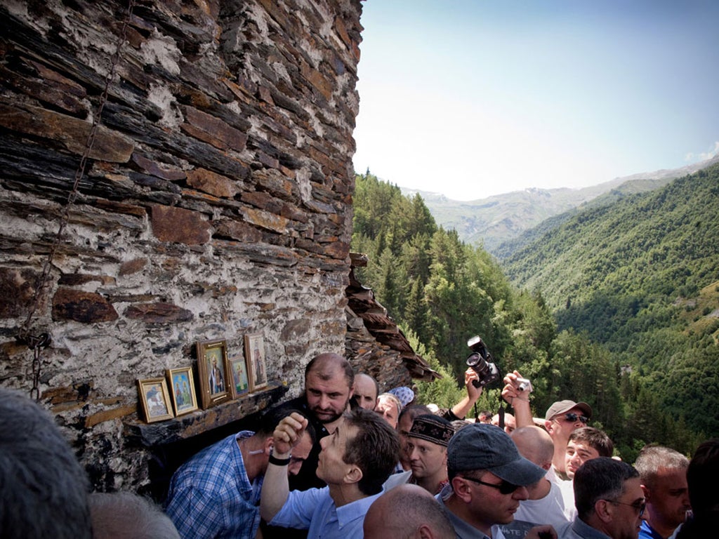 Bidzina Ivanishvili crosses himself in front of a 12th-century church during his campaign tour of Georgia's Svaneti mountain area