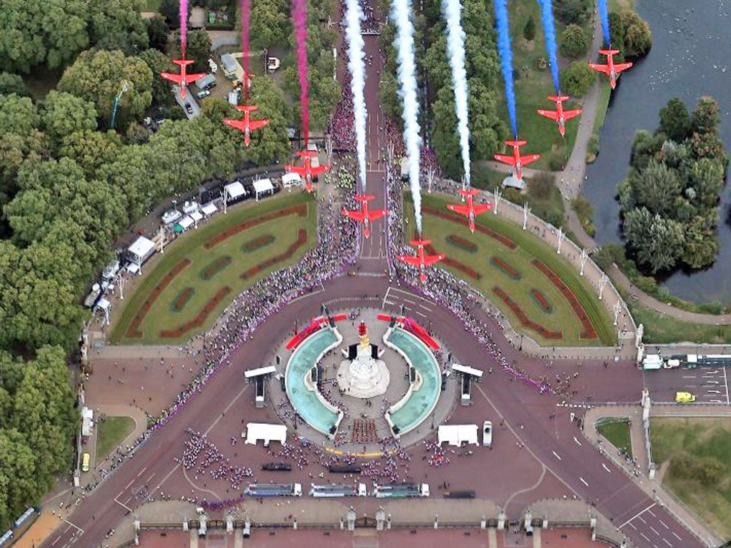 The Red Arrows Royal Air Force Aerobatic Team fly in formation over the Queen Victoria Memorial next to Buckingham Palace during the London 2012 Victory Parade for Team GB and Paralympic GB athletes