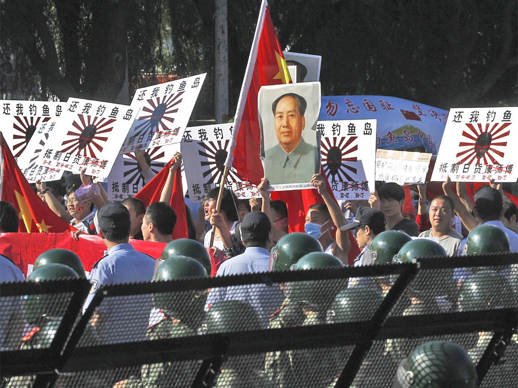 Protesters, holding portraits of the late Communist leader Mao Zedong, outside the Japanese Embassy yesterday