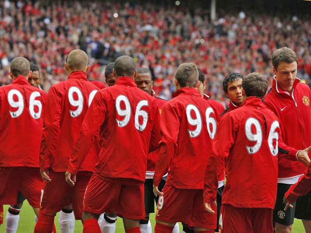 Liverpool and Manchester United players shake hands before their English Premier League soccer match at Anfield