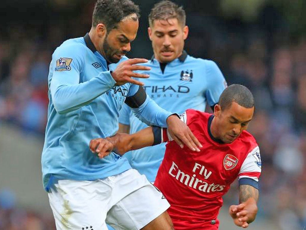 Theo Walcott (right) finds the going tough against Man City yesterday