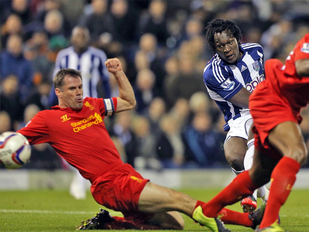 Romelu Lukaku shoots past Liverpool defender Jamie Carragher