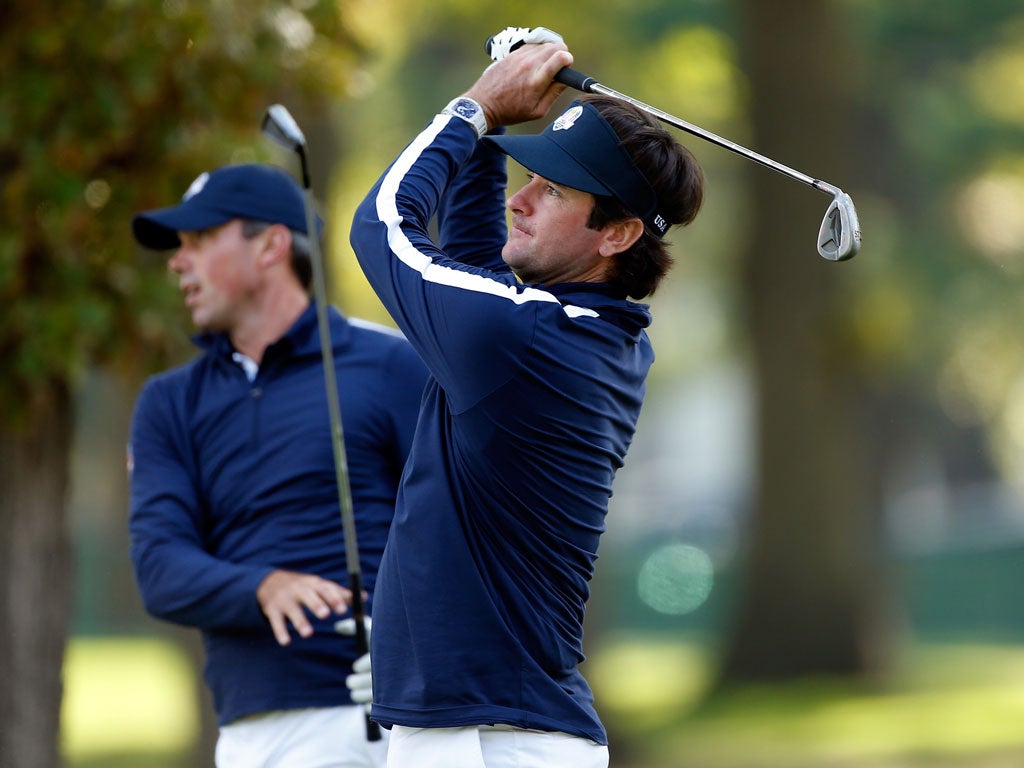 Bubba Watson (right) hits a practice shot watched by US team-mate Matt Kuchar yesterday