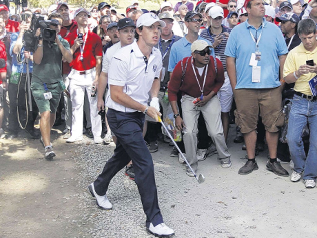 Rory McIlroy watches his approach shot to the fifth green