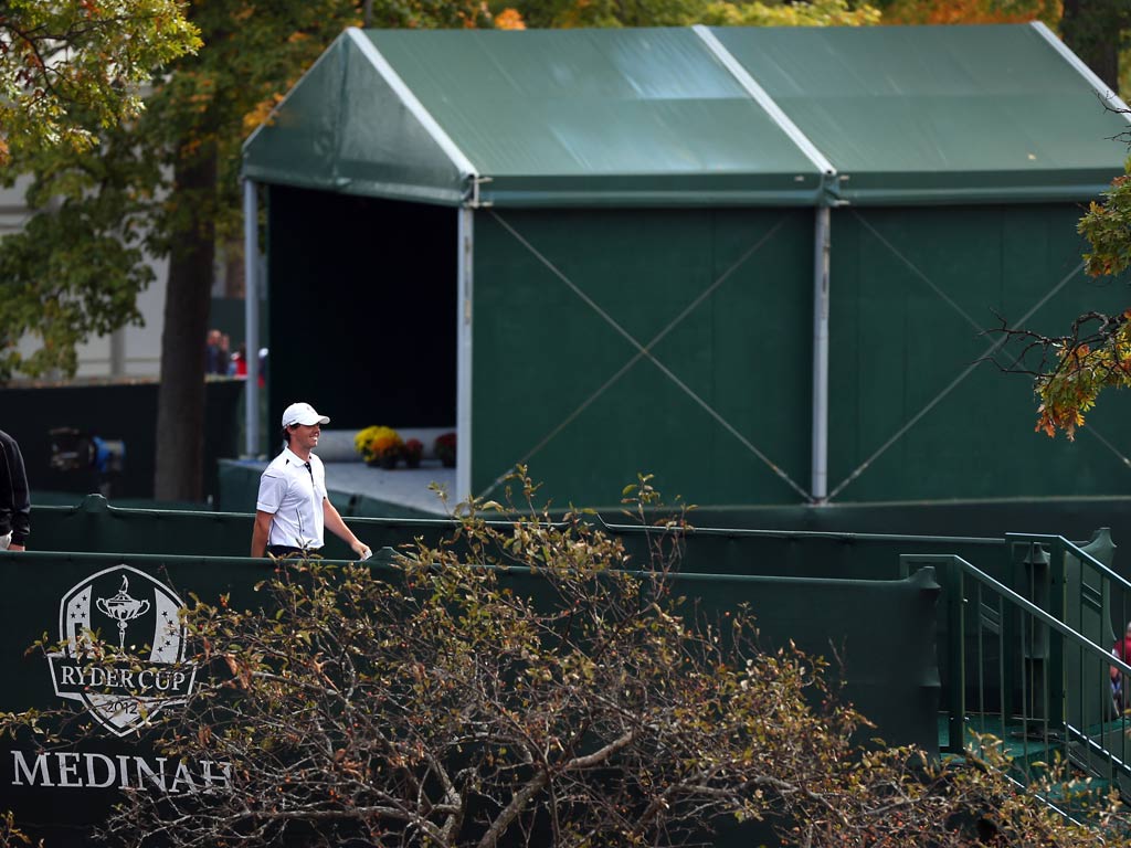 Rory McIlroy walks to the first tee after arriving late