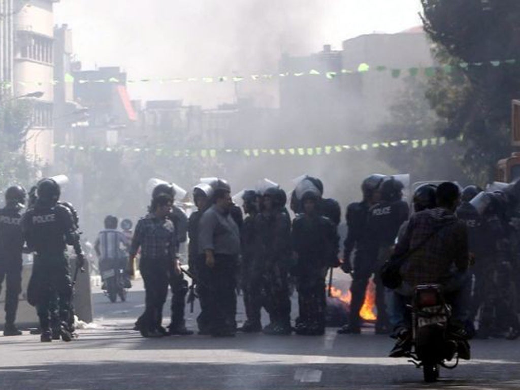 Iranian riot police move in as garbage is set on fire by protestors in central Tehran