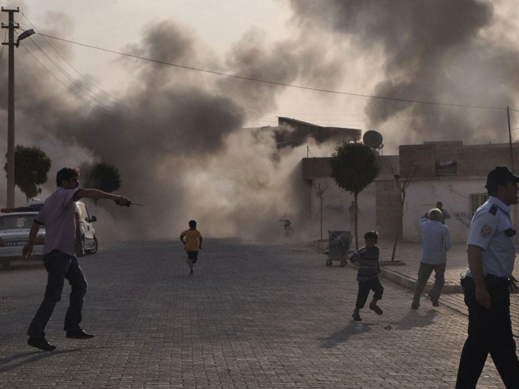 Smoke rises over the streets after an mortar bomb landed from Syria in the border village of Akcakale