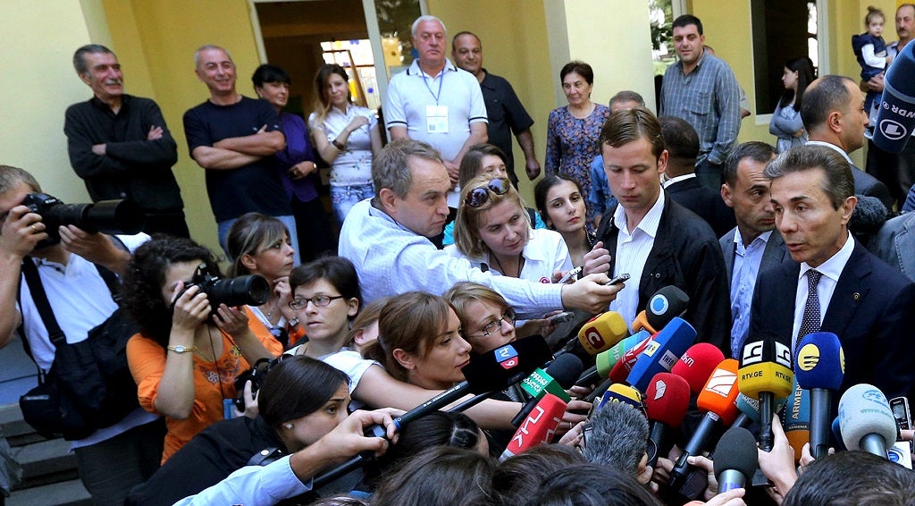 Bidzina Ivanishvili (R) speaks to journalists outside a polling station in Tbilisi