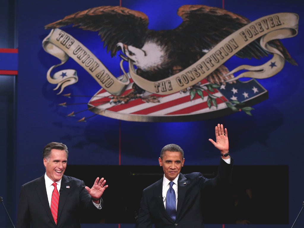 Barack Obama and Mitt Romney wave to the audience during the Presidential Debate in Denver