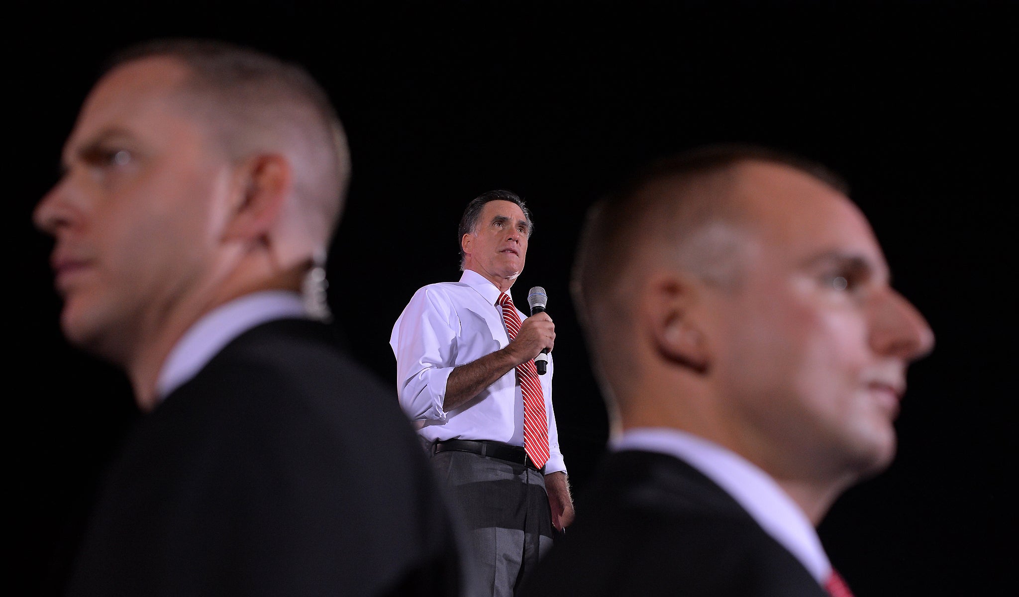 US Republican presidential candidate Mitt Romney speaks as secret service members keep guard during a campaign rally in Fishersville, Virginia