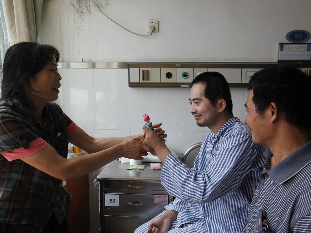 Zhang Tingzhen, who is unable to speak or walk properly, with his parents in Shenzhen hospital