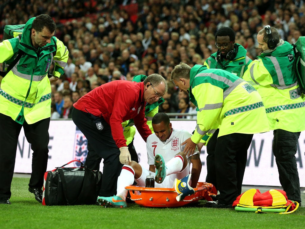 Theo Walcott receives assistance after picking up an injury against San Marino last night