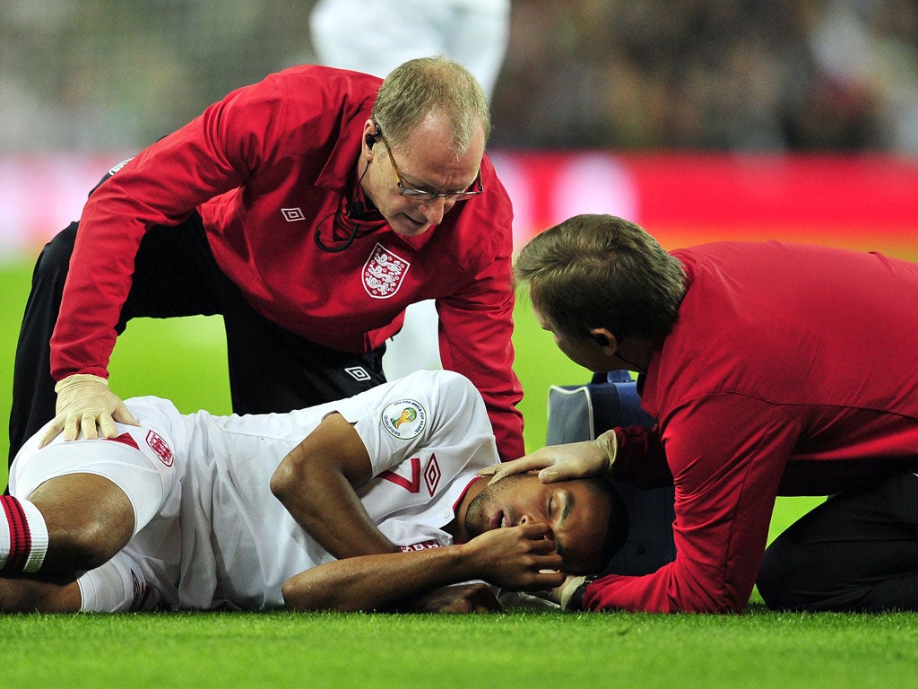 Theo Walcott is attended by medical staff as he lies injured after clashing with San Marino's goalkeeper Aldo Simoncini