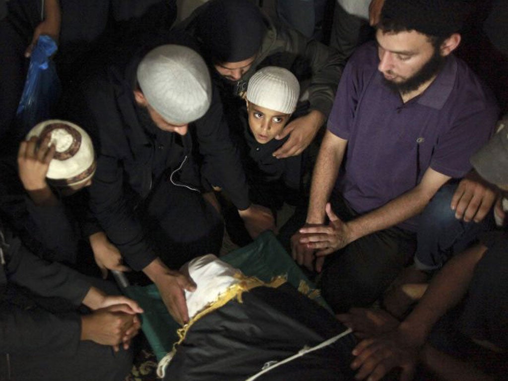 Ahmed, son of the Salafist leader Islamist Hisham al-Saedni, sits next to his father’s body at his funeral in a Gaza refugee camp yesterday