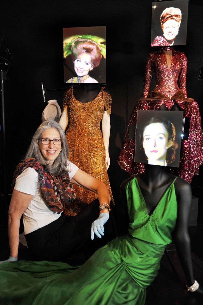 Hollywood costume designer and curator of the Hollywood Costume exhibition Deborah Nadoolman Landis (left), sits with the costumes worn by (clockwise) Barbra Streisand in 'Hello Dolly', Ginger Rogers in 'Lady in the dark' , and Keira Knightley in Atonement', before the opening of the 130 costumes on display on the 20th October at the Victoria & Albert Musuem in London