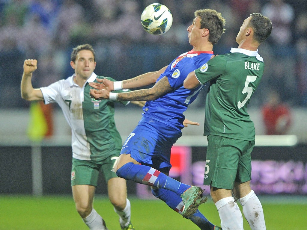 Croatia's Marijo Mandzukic keeps the ball from Joe Allen and Darcy Blake of Wales