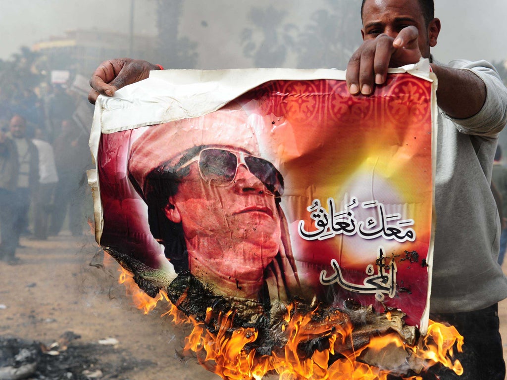 Libyan protesters burn images of Gaddafi