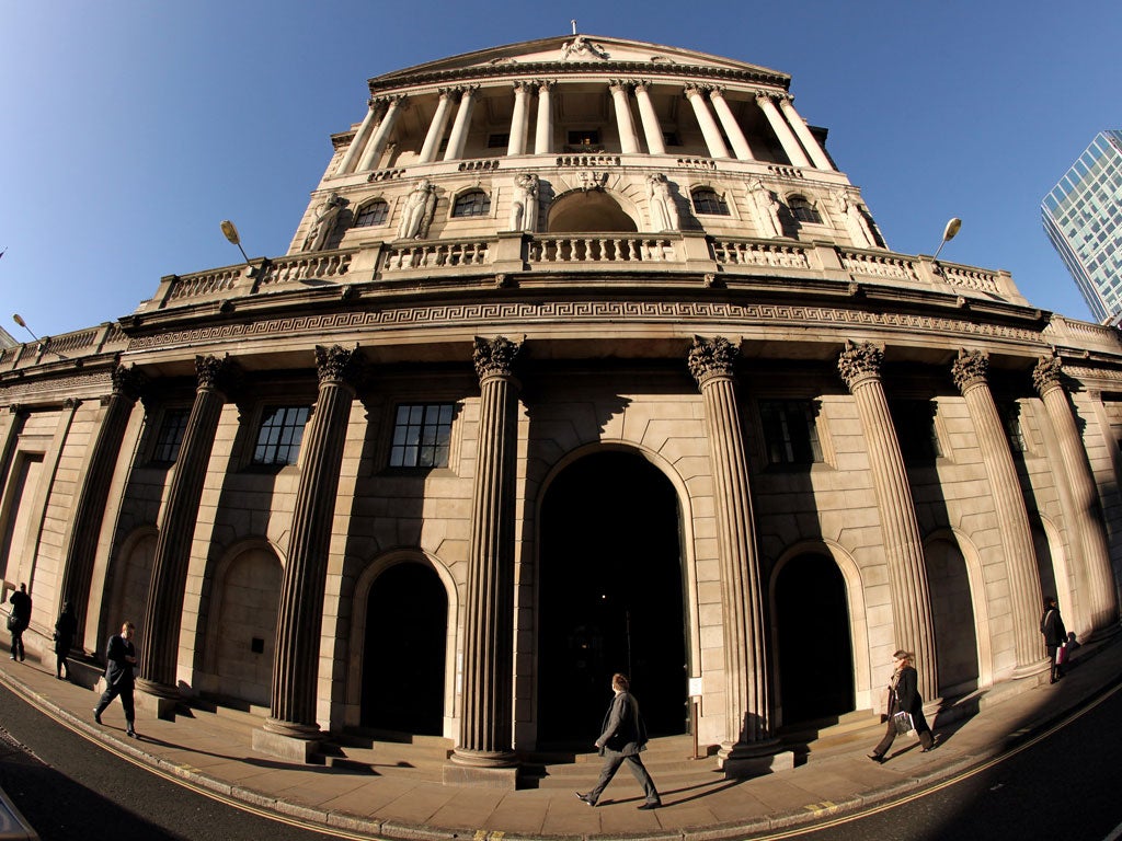 Businessmen walk past the Bank of England in the financial district in London, England.