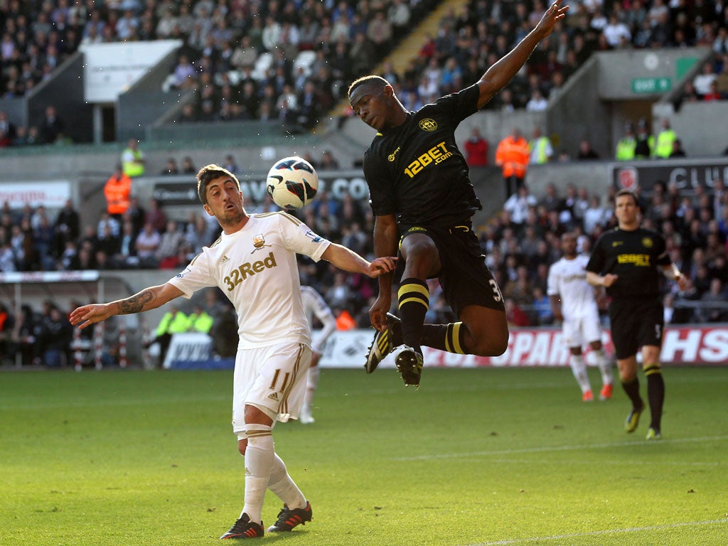 Maynor Figueroa of Wigan Athletic wins the arial battle for the ball with Pablo Hernandez of Swansea