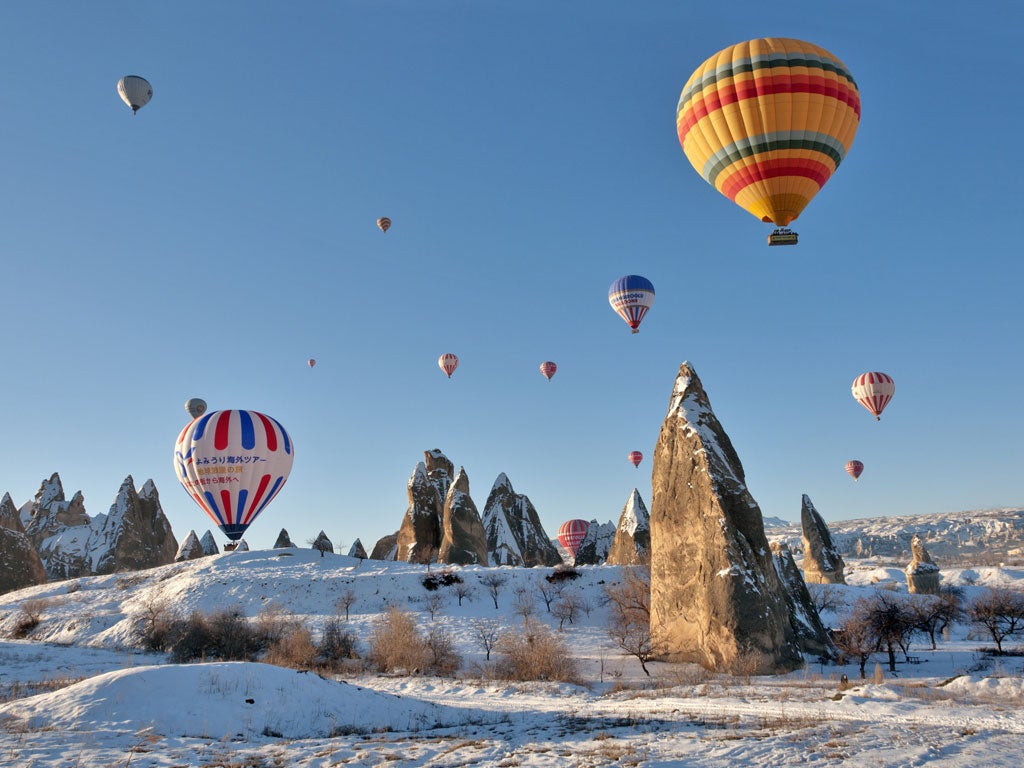 High life: Hot-air balloons float above snow-covered Cappadocia