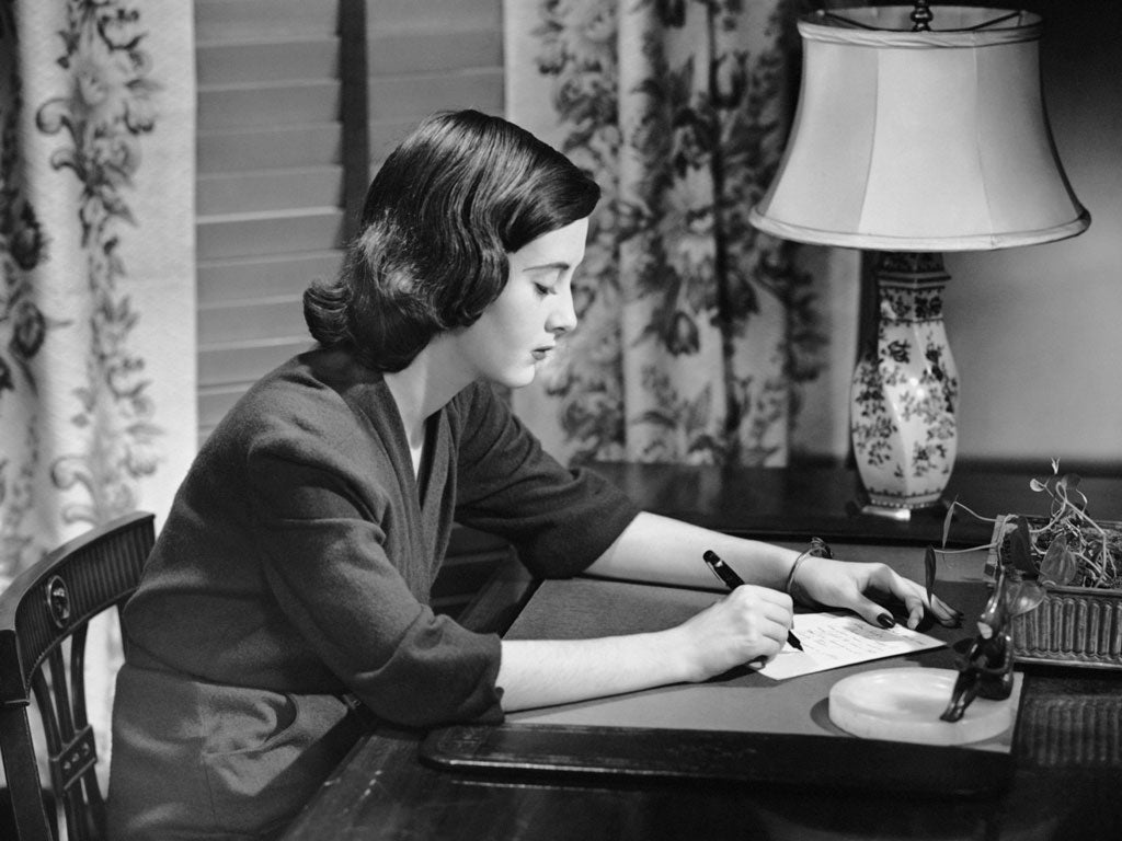 Portrait of woman writing letter at desk